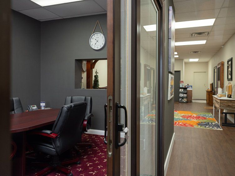 A conference room with a table and chairs and a clock on the wall