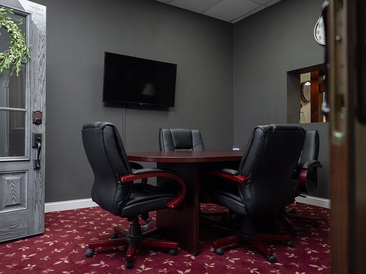 A conference room with a table and chairs and a clock on the wall