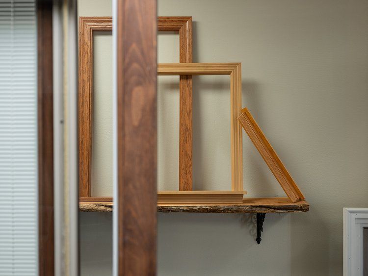 Three wooden frames are stacked on top of each other on a shelf.
