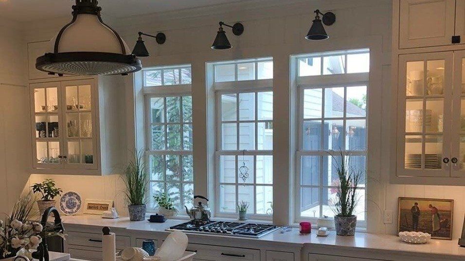 A kitchen with a lot of windows and white cabinets.