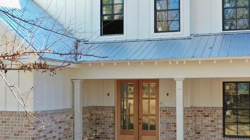 A white house with a blue roof and a porch