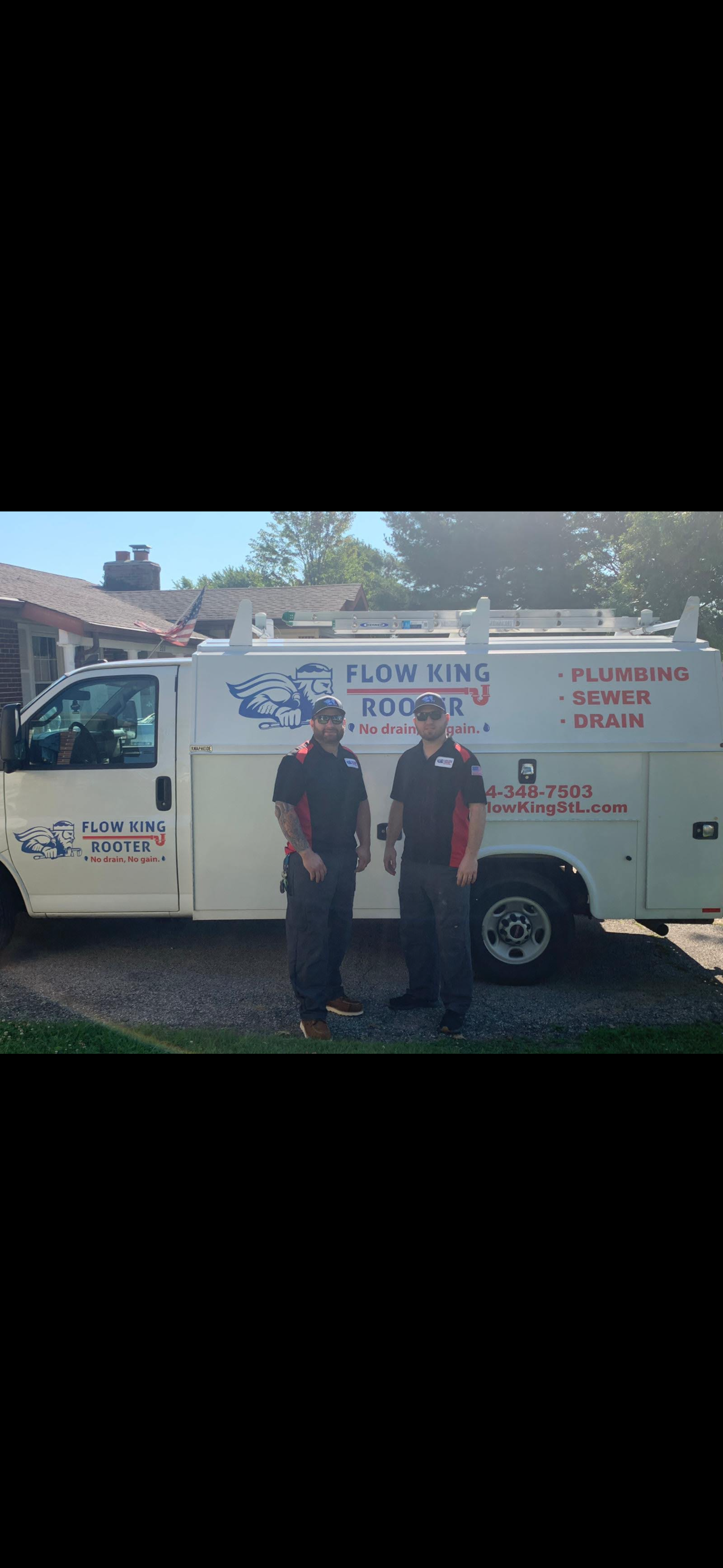 Two men standing next to a white service van with company logo.