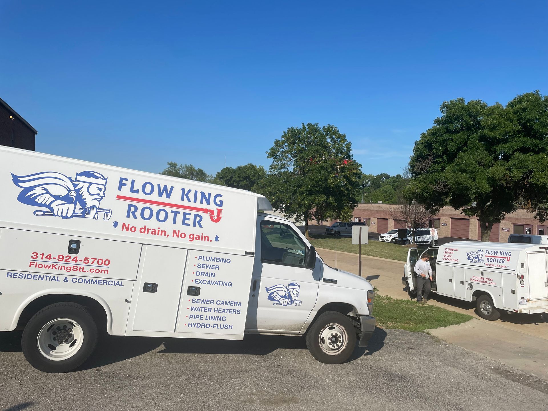 White Flow King Rooter trucks parked on a sunny day.