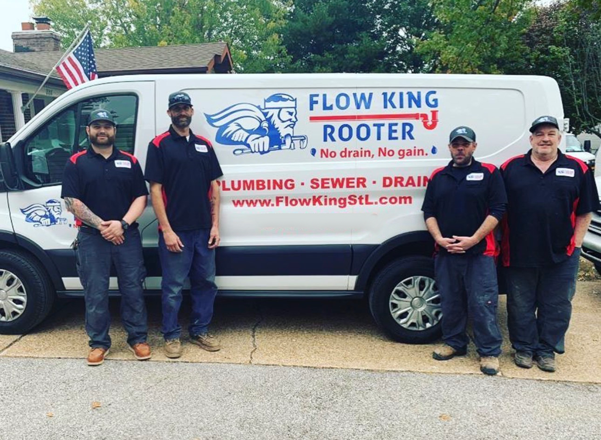 Flow King Rooter team standing in front of their work van, text on side, American flag.