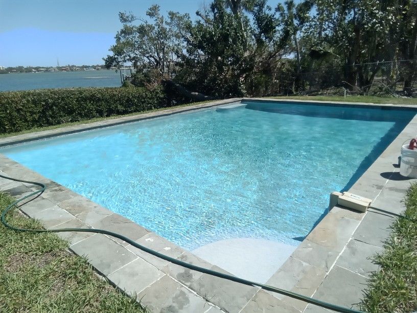 A large swimming pool with a hose attached to the edge.