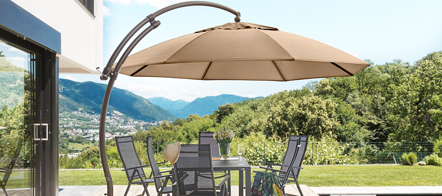 A large umbrella is sitting on a patio next to a table and chairs.