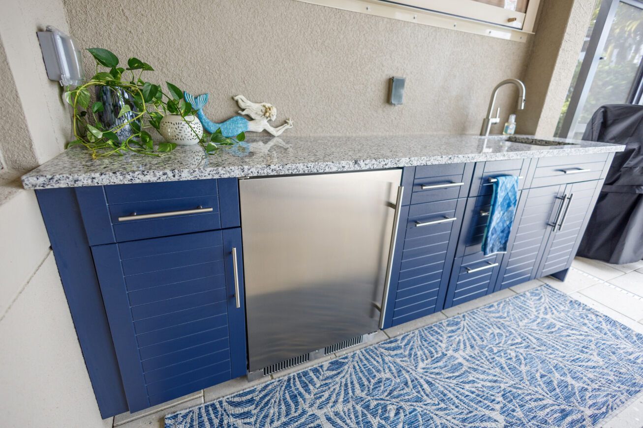 a kitchen with blue cabinets and a stainless steel refrigerator