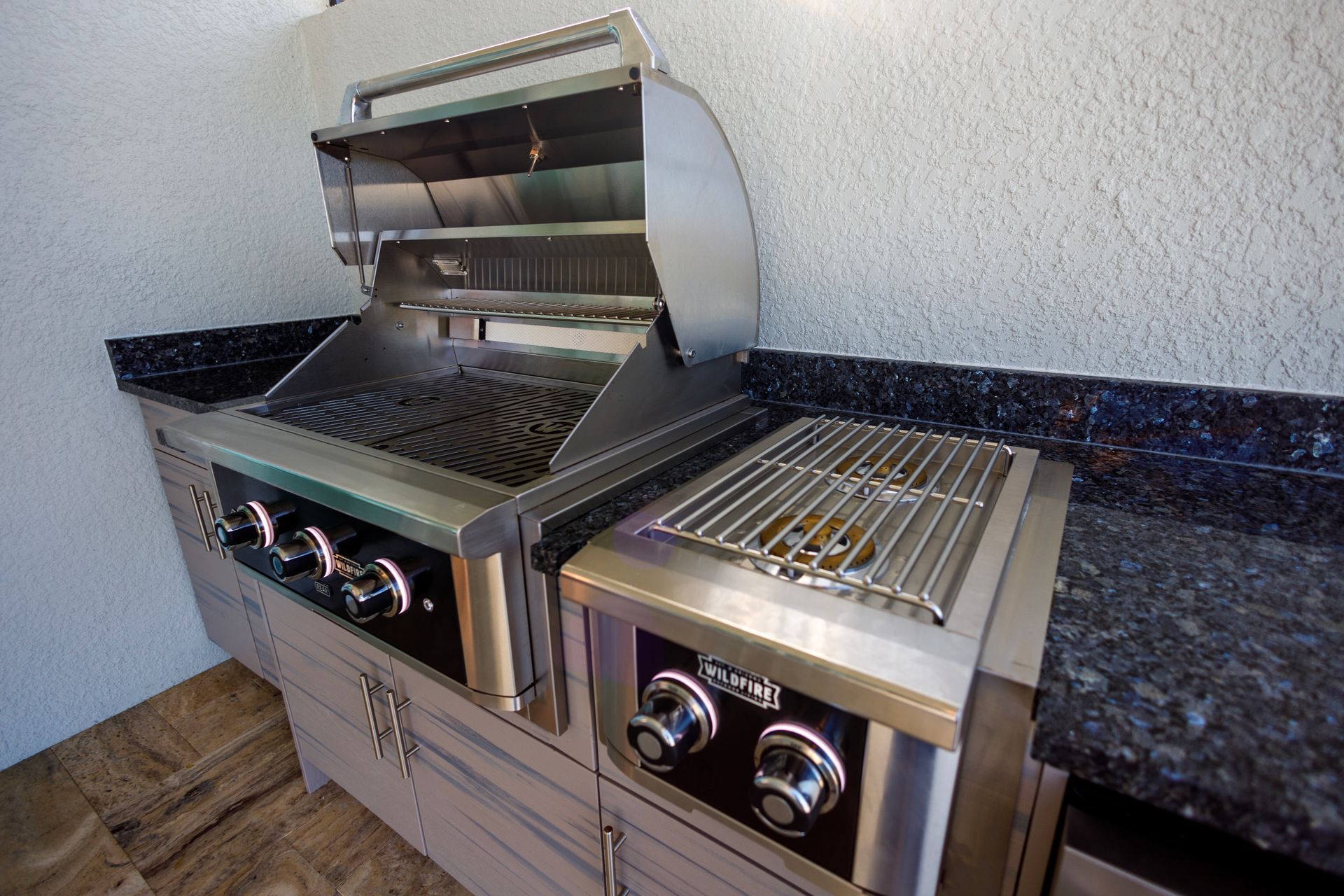 A stainless steel grill is sitting on a counter in a kitchen