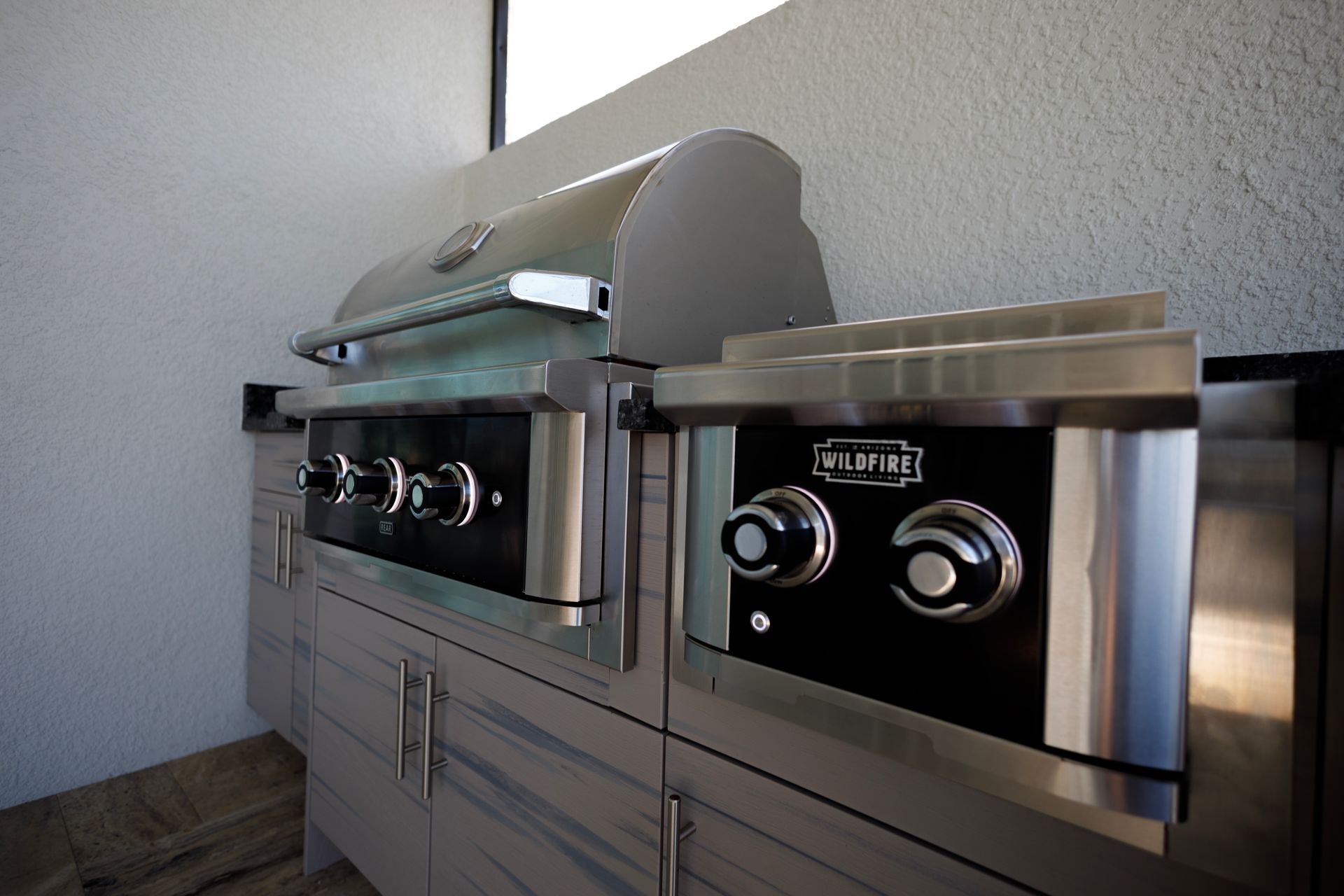 A stainless steel grill is sitting on top of a counter in a kitchen