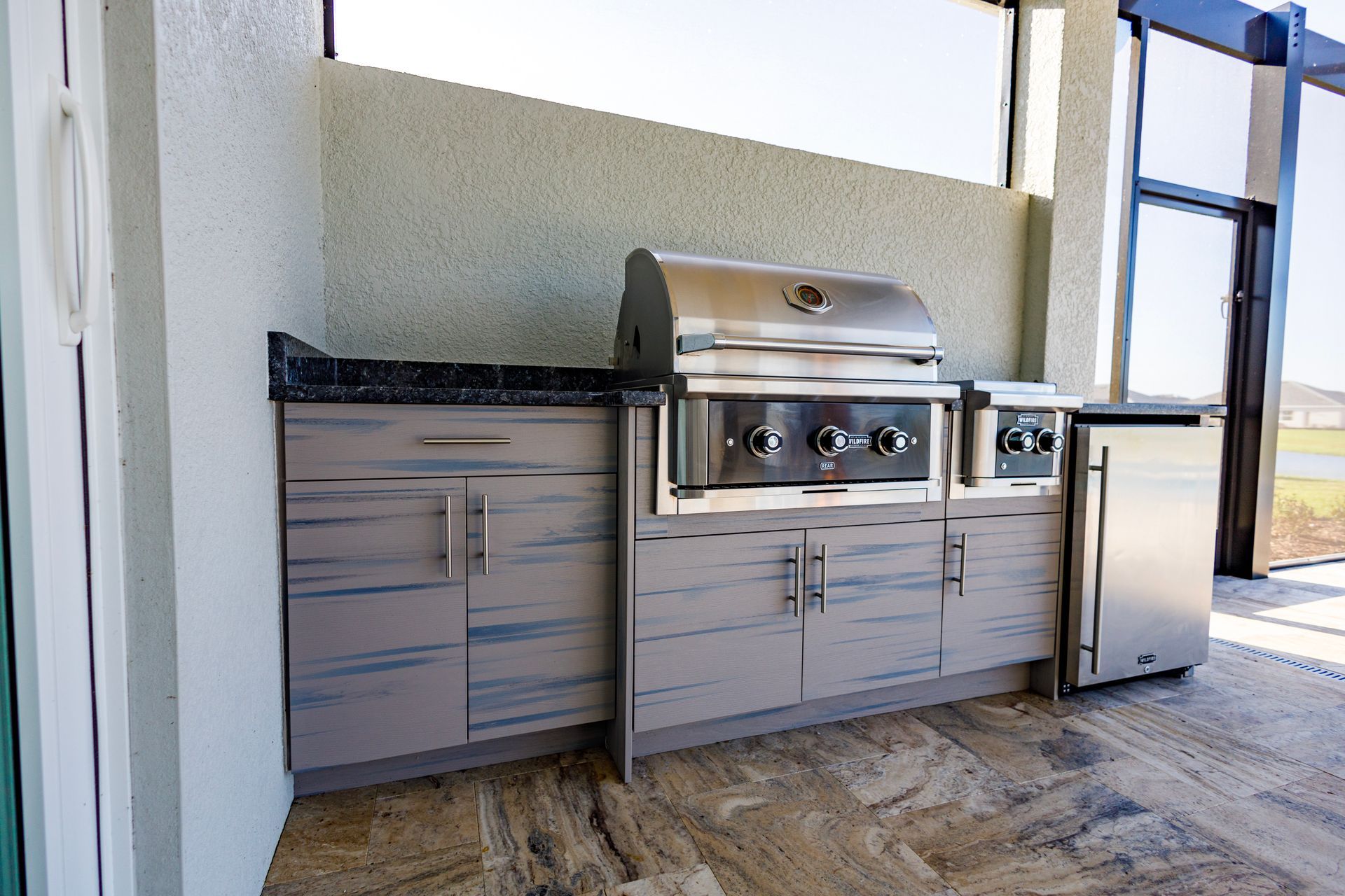 An outdoor kitchen with stainless steel appliances and cabinets