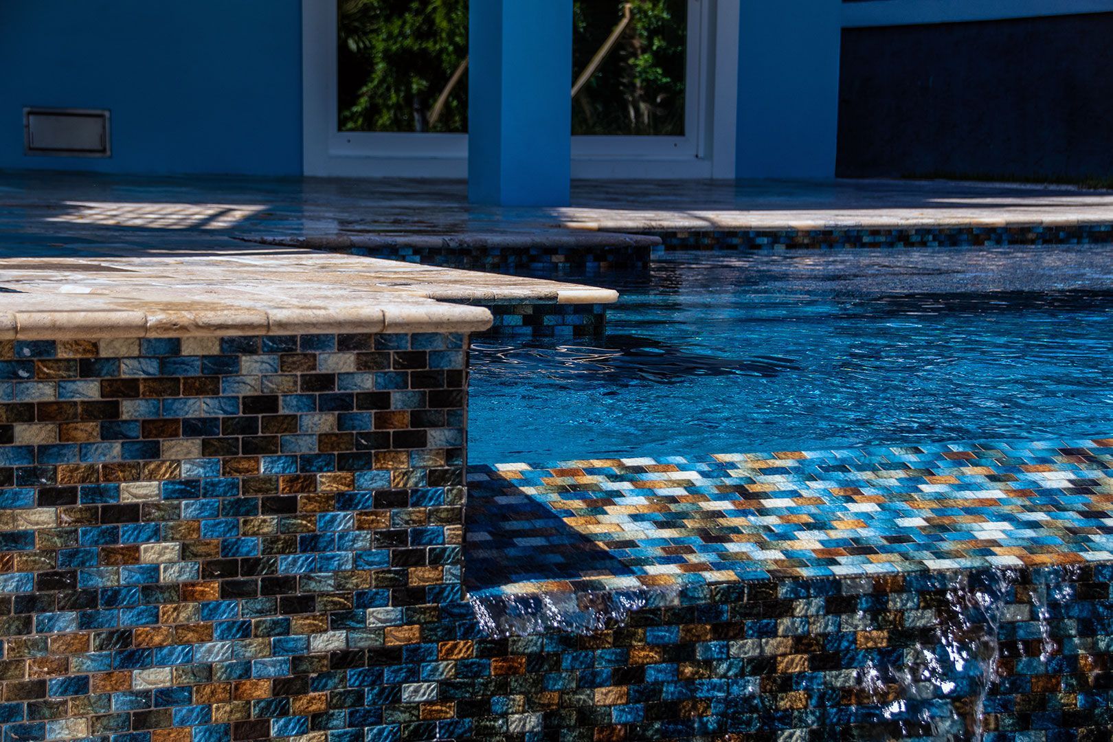 A large swimming pool with a blue house in the background.