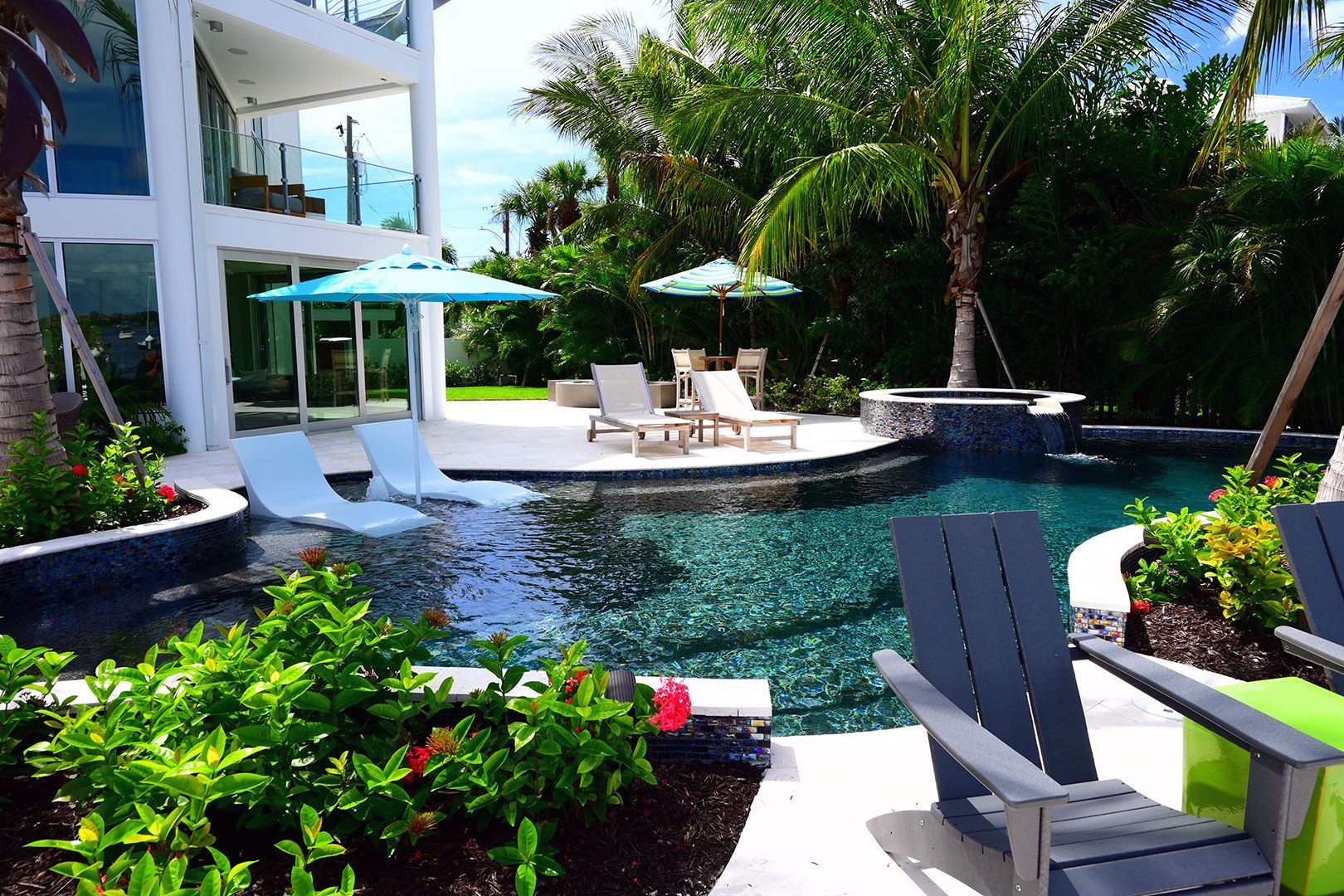 A large swimming pool surrounded by chairs and umbrellas.