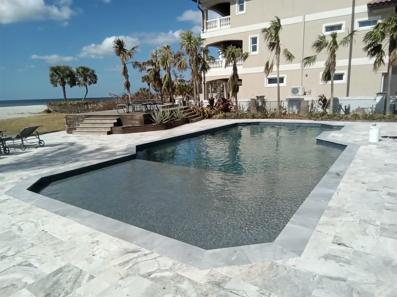A large swimming pool with a house in the background