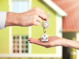 Handing over house key with a house background