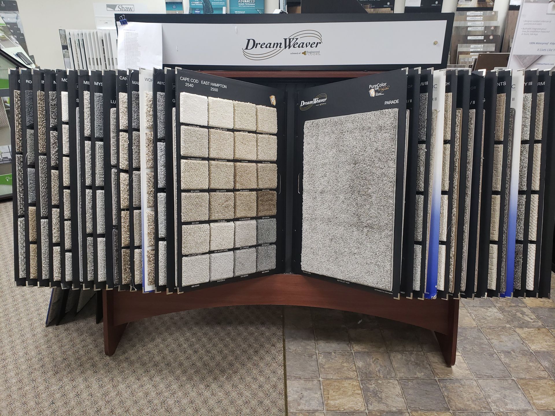 Stone tile display stand in a showroom, with multiple gray and beige tile samples.