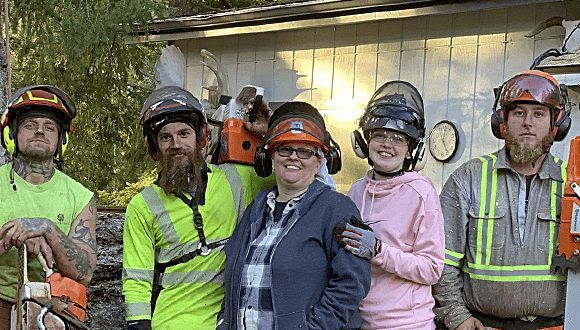 A group of people wearing hard hats and safety vests are posing for a picture.