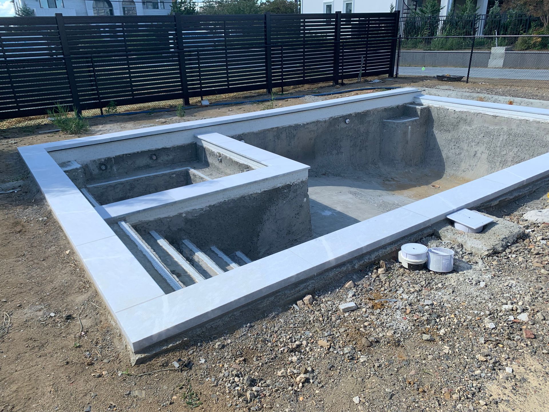 A large swimming pool is being built in a backyard.