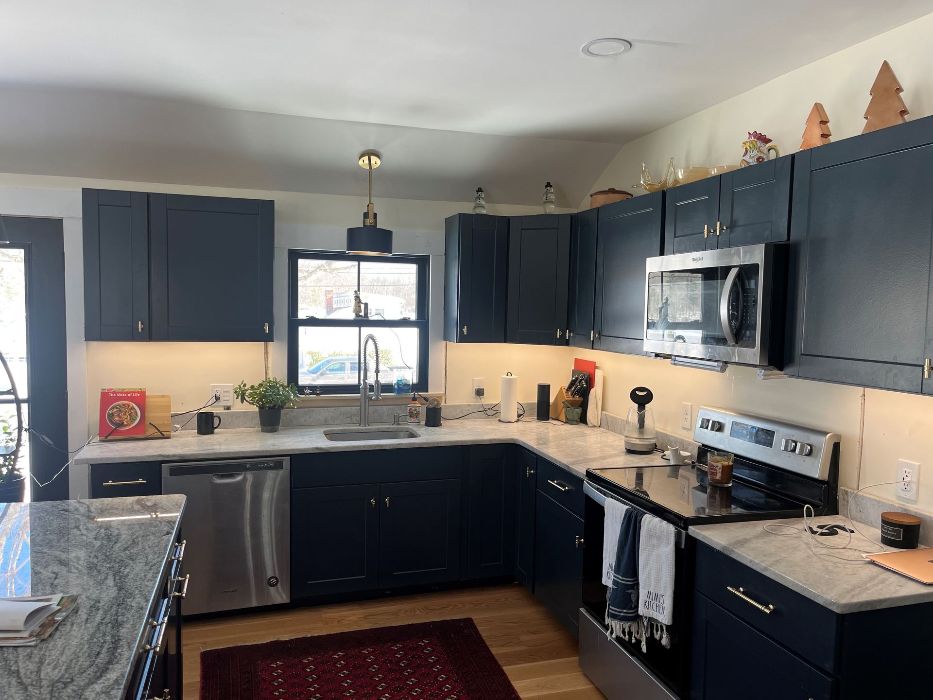 a kitchen with blue cabinets and stainless steel appliances