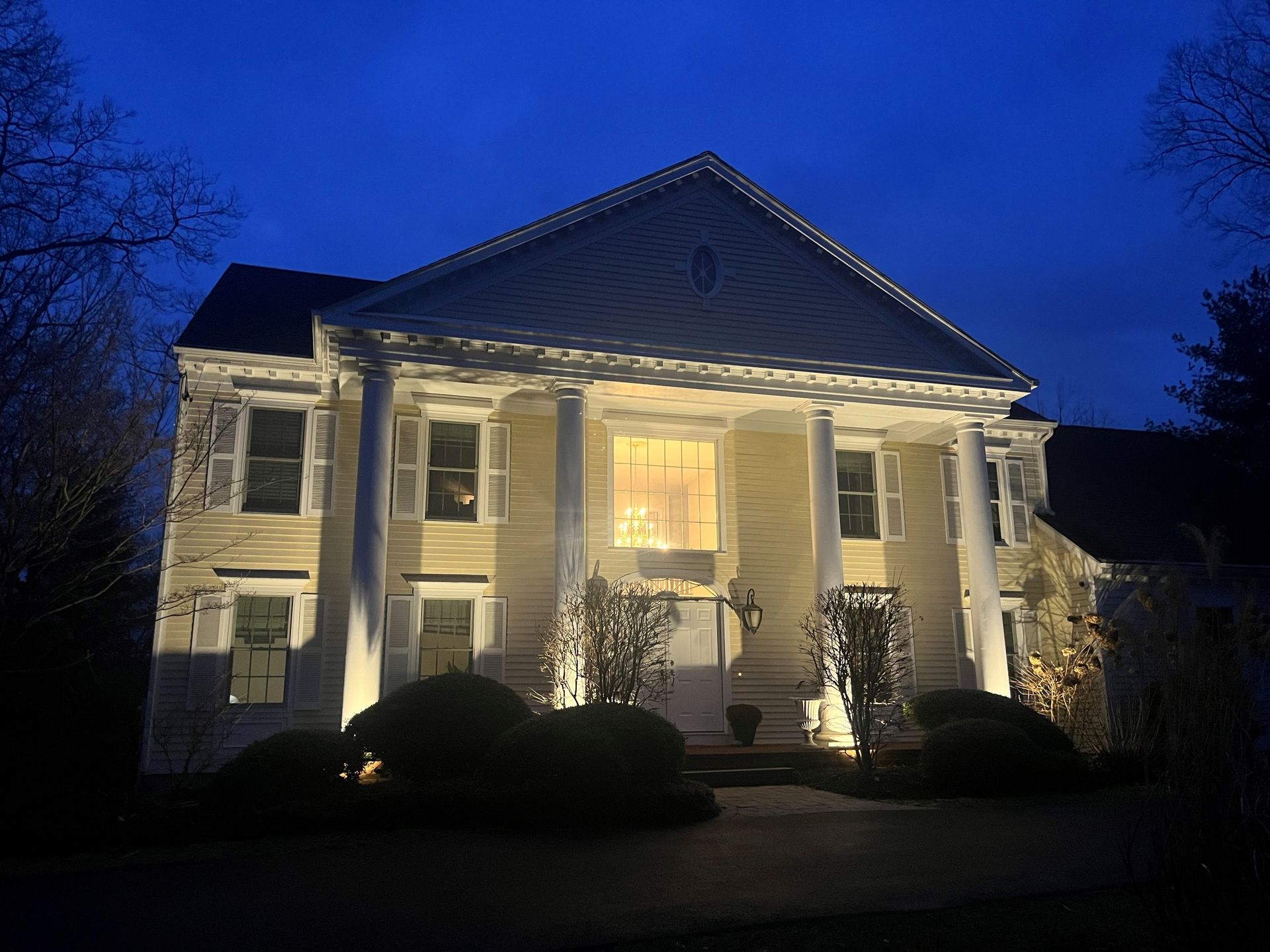 a large house with columns is lit up at night