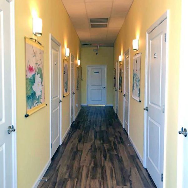 A long hallway with yellow walls and white doors
