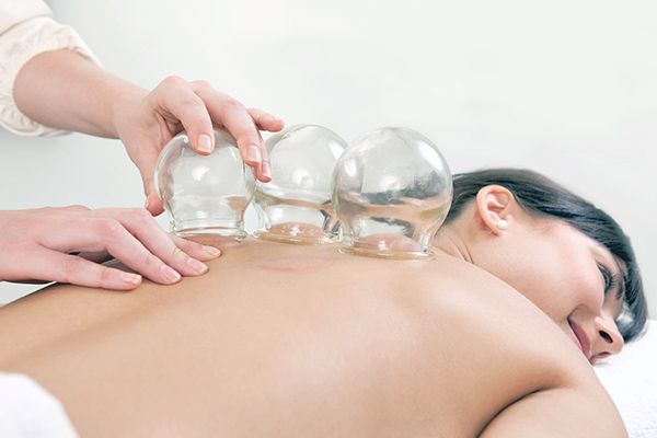 A woman is getting a cupping treatment on her back.