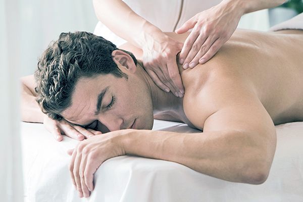 A man is laying on a massage table getting a massage.