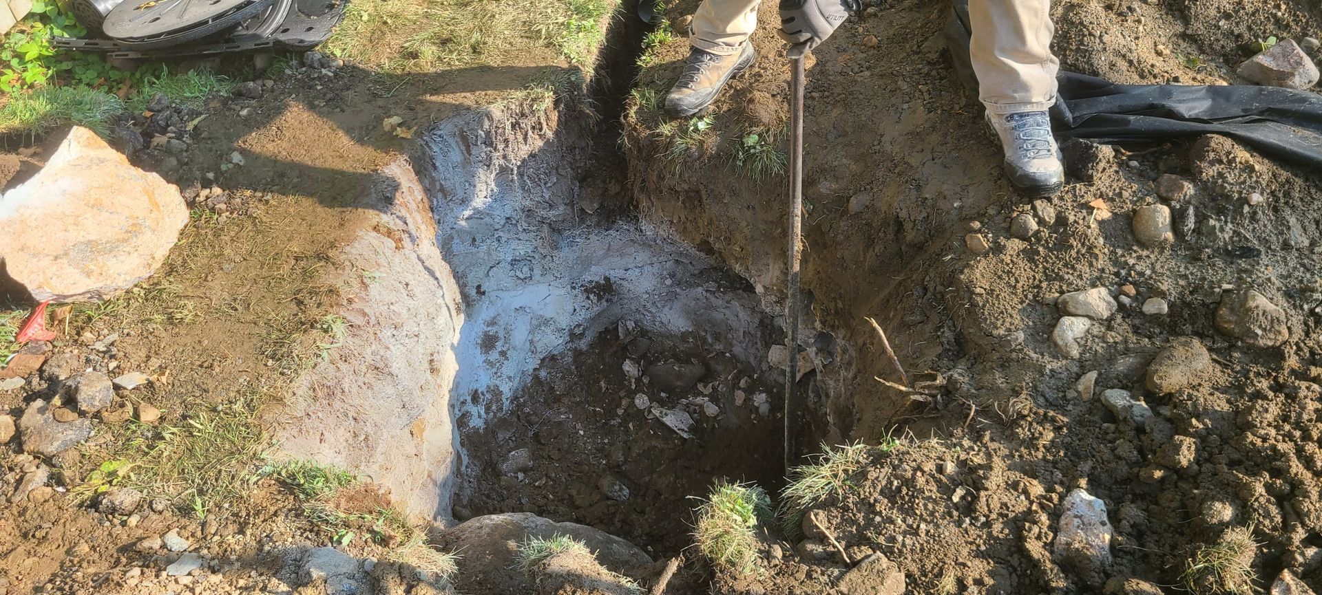A person is digging a hole in the ground with a shovel.