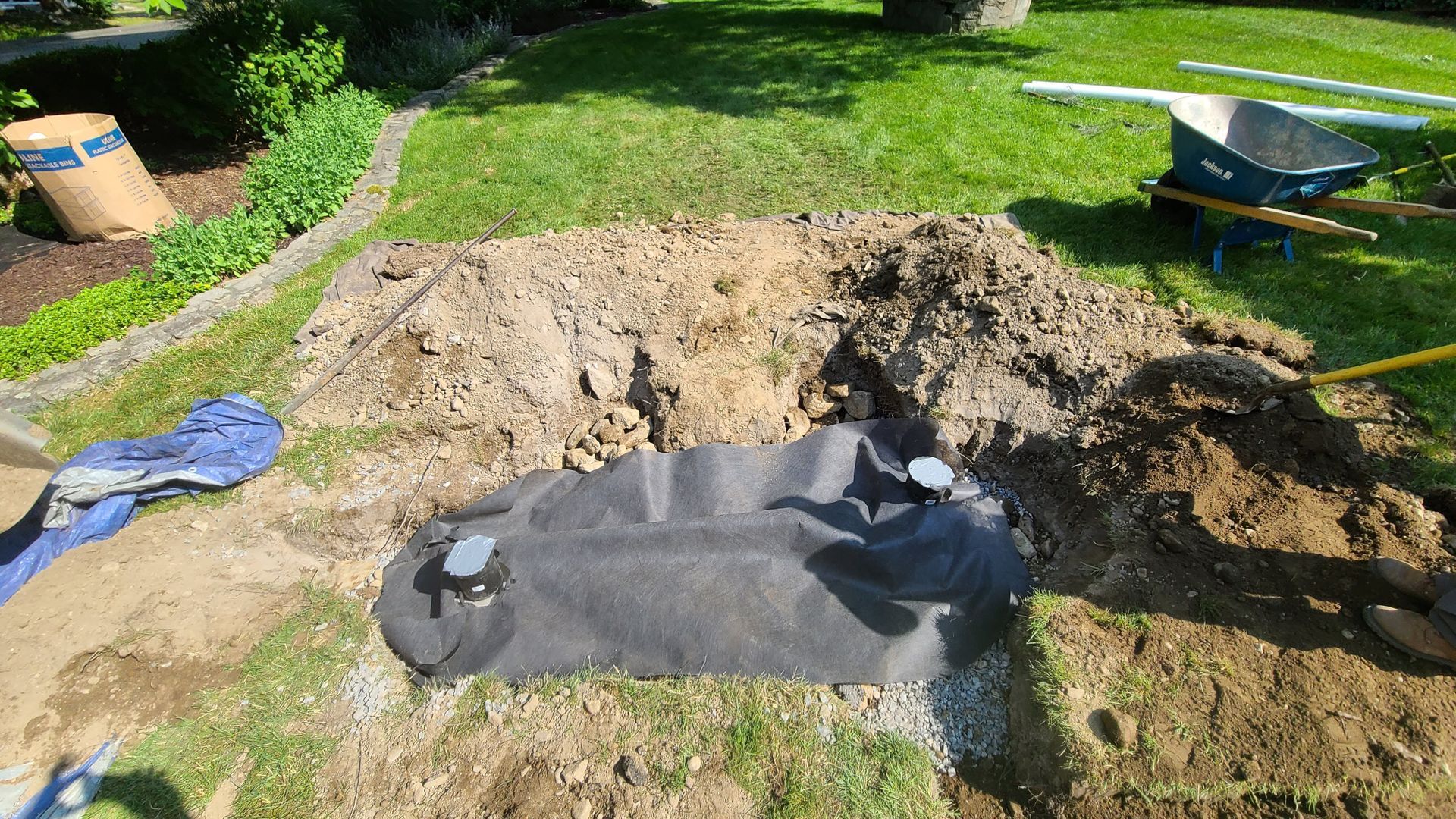 A person is digging a hole in the ground in a yard.