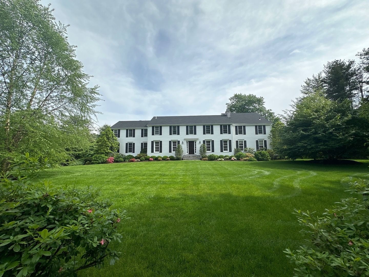 A large white house with a large lawn in front of it.