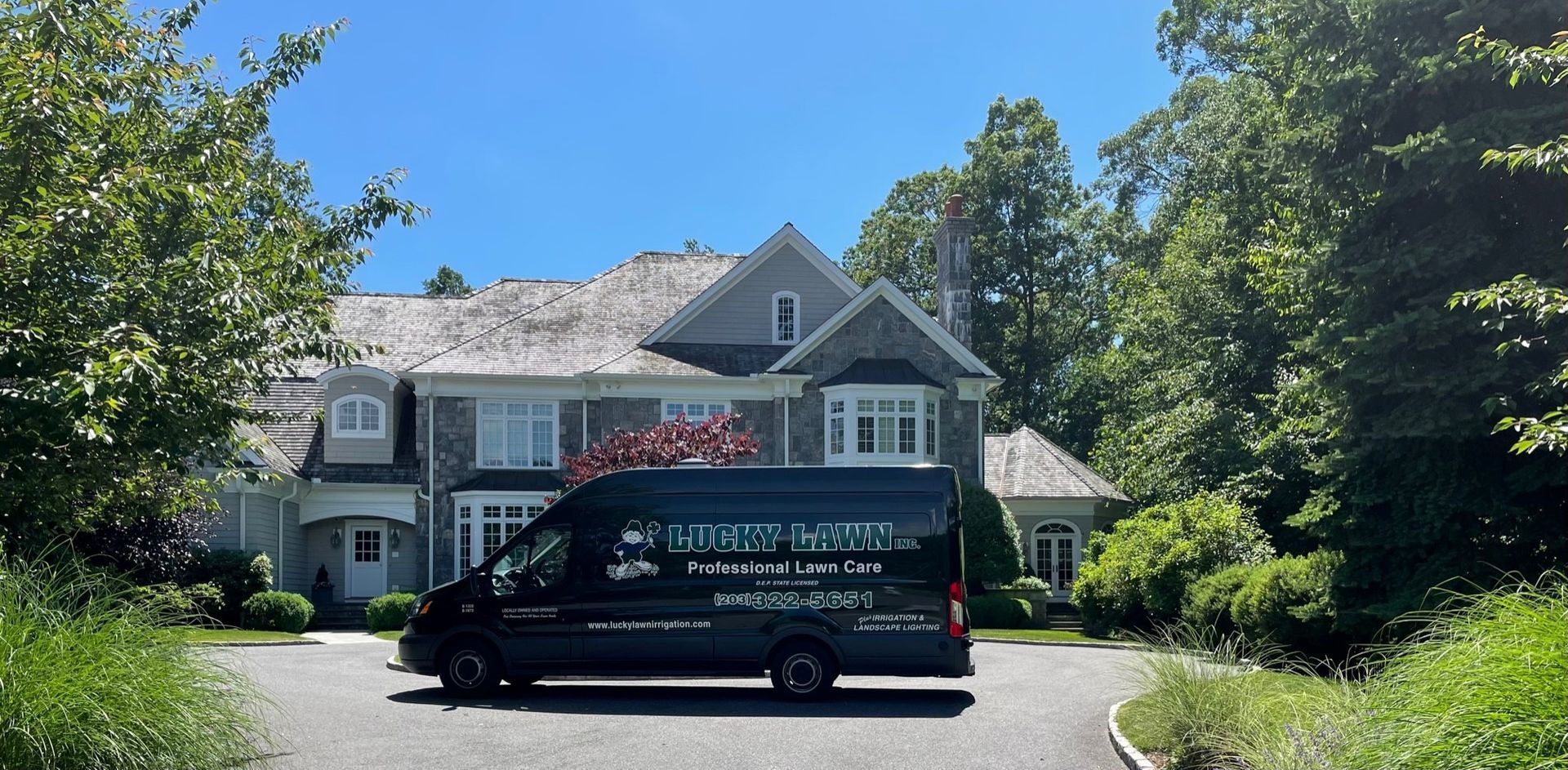 Lucky Lawn service ban parked in front of a house