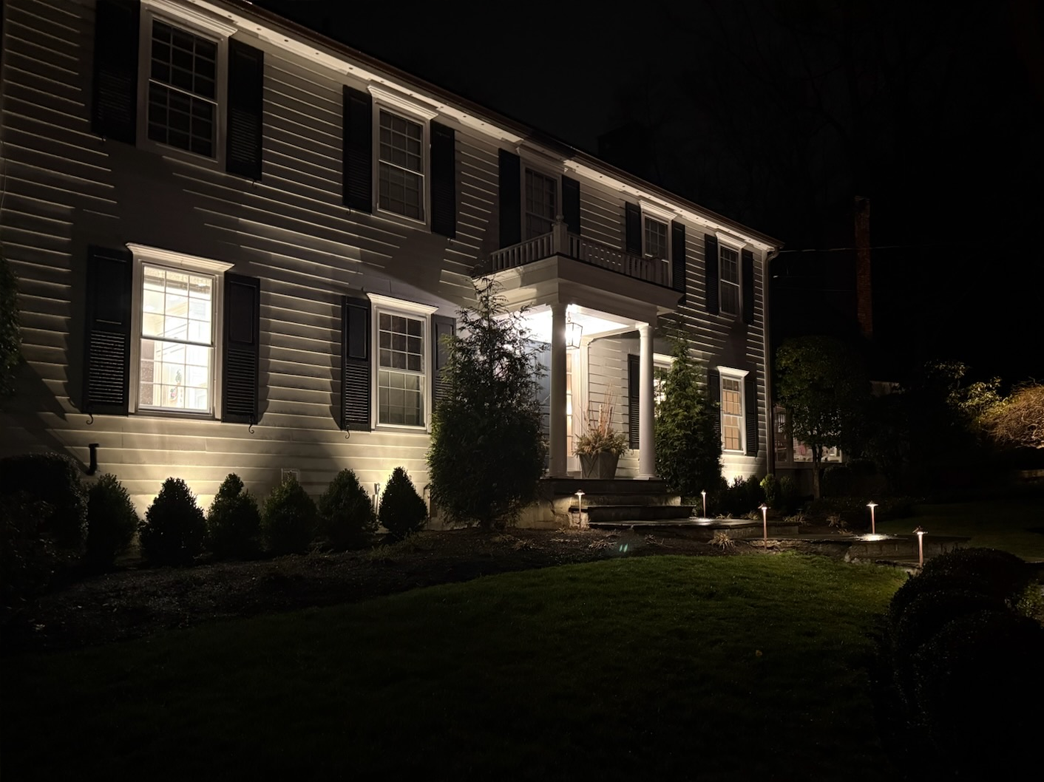 The front of a house is lit up at night.