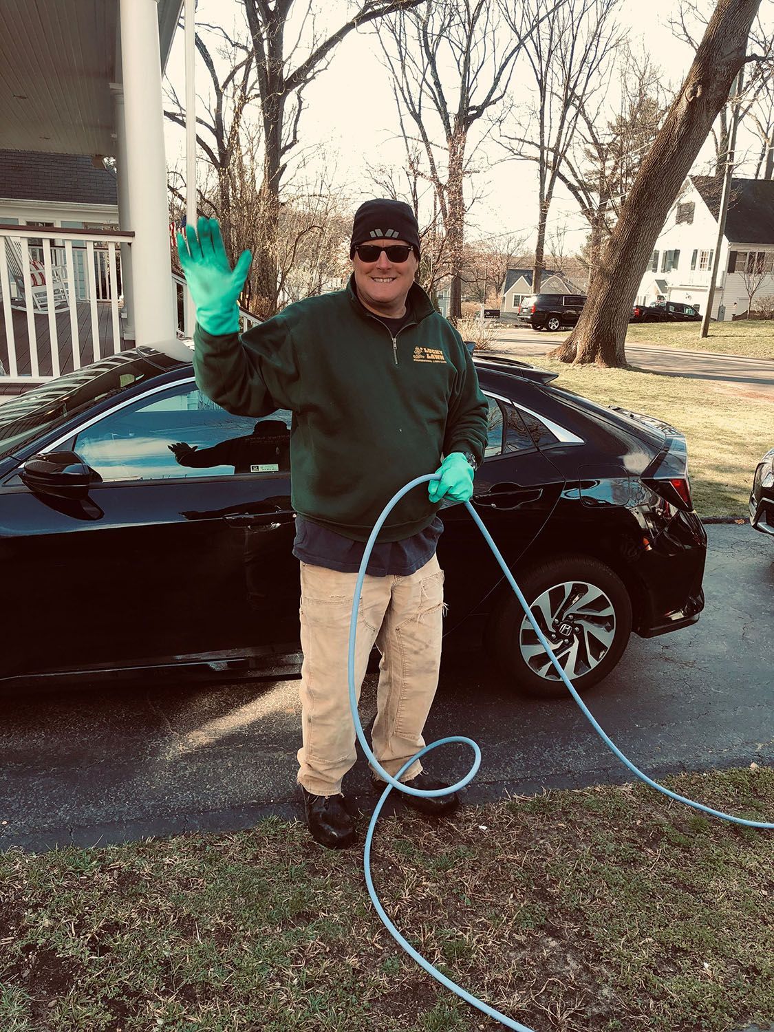 Man waving while holding a cable/hose