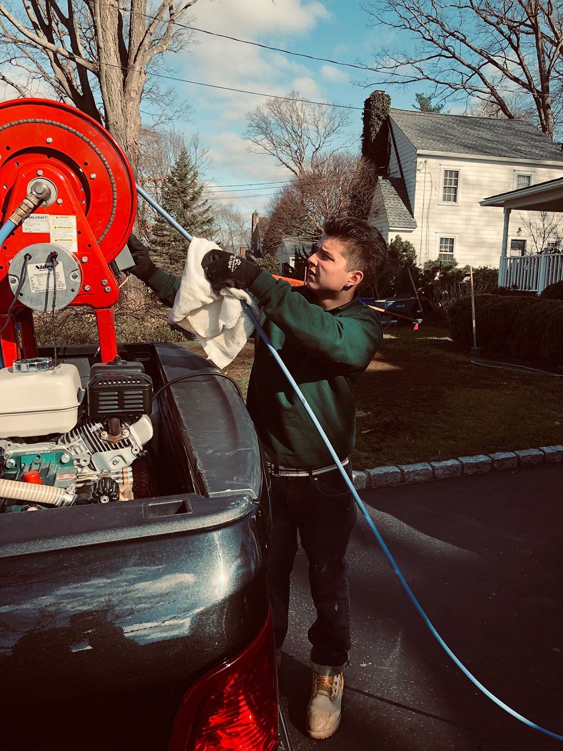 Man pulling a long cable/hose from the truck