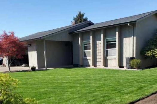 A house with a lush green lawn in front of it.