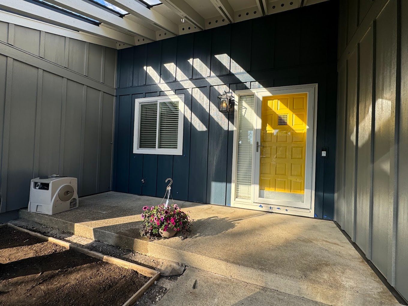 A blue house with a yellow door and a window.
