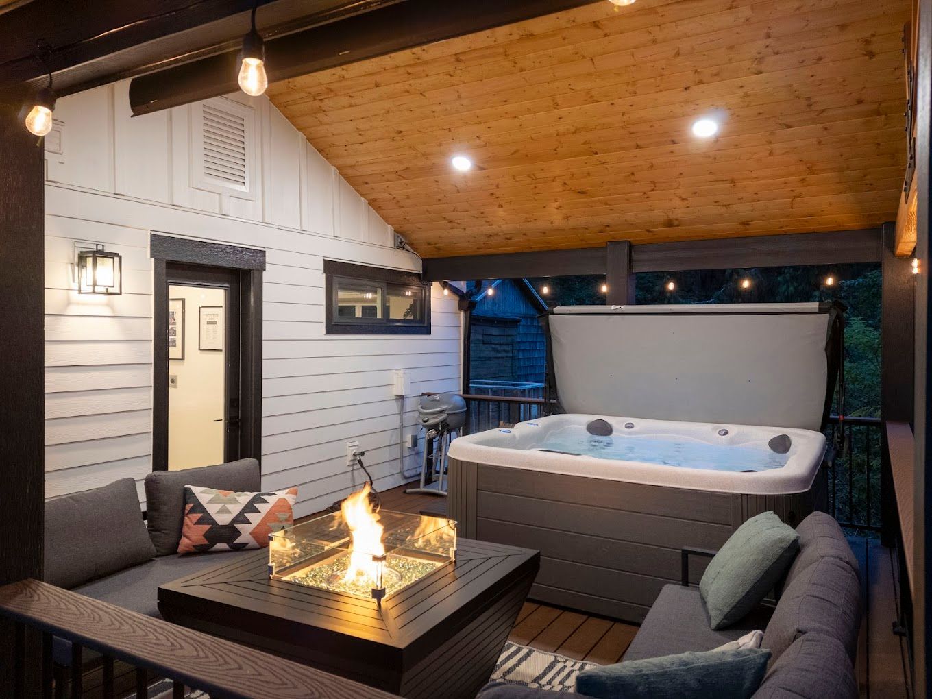 There is a hot tub on the deck with a fire pit.