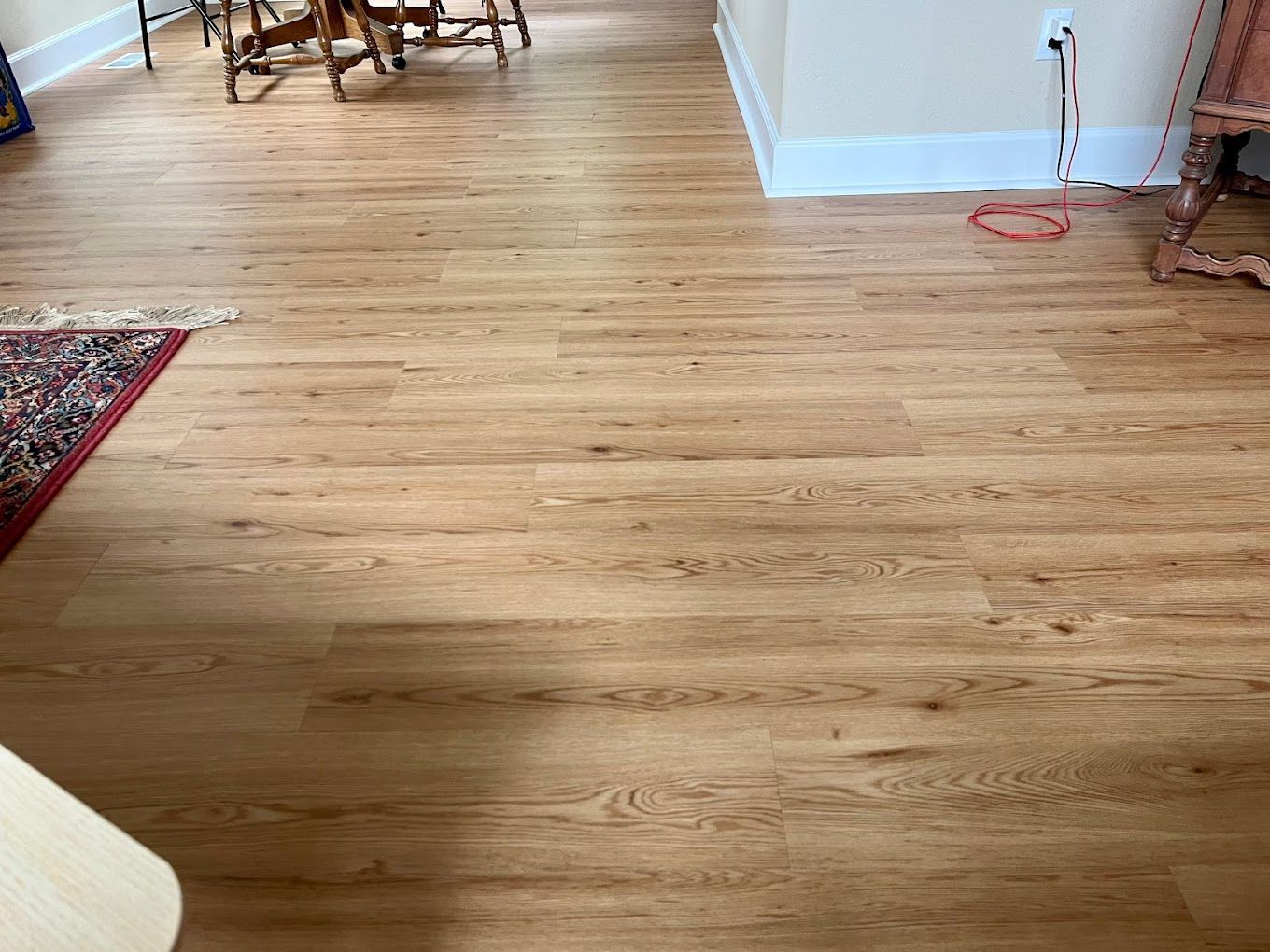 A living room with a wooden floor and a rug.