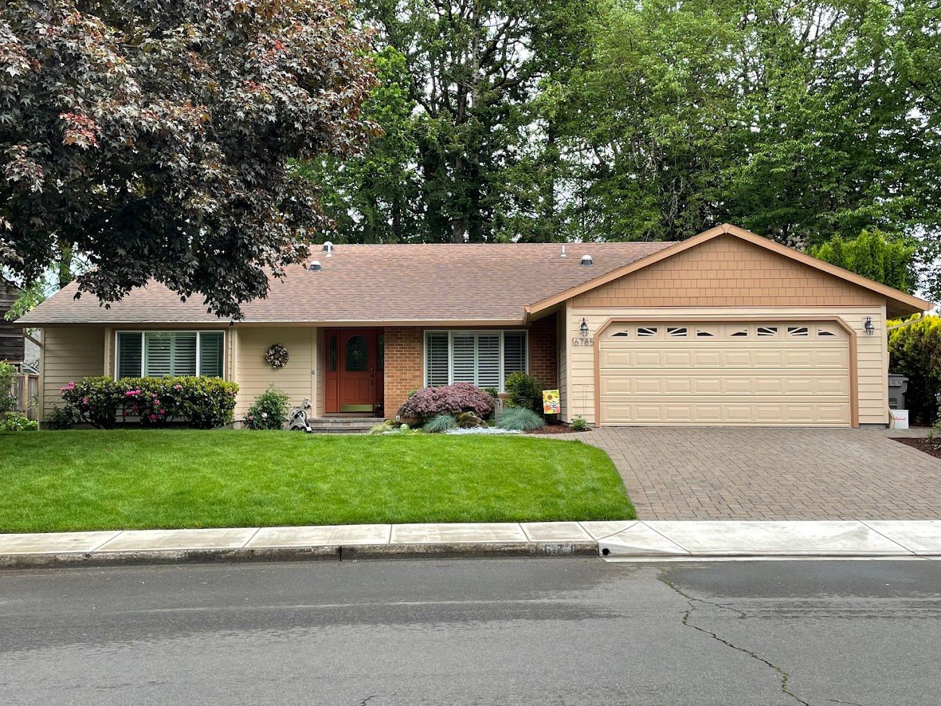A house with a large garage and a red door