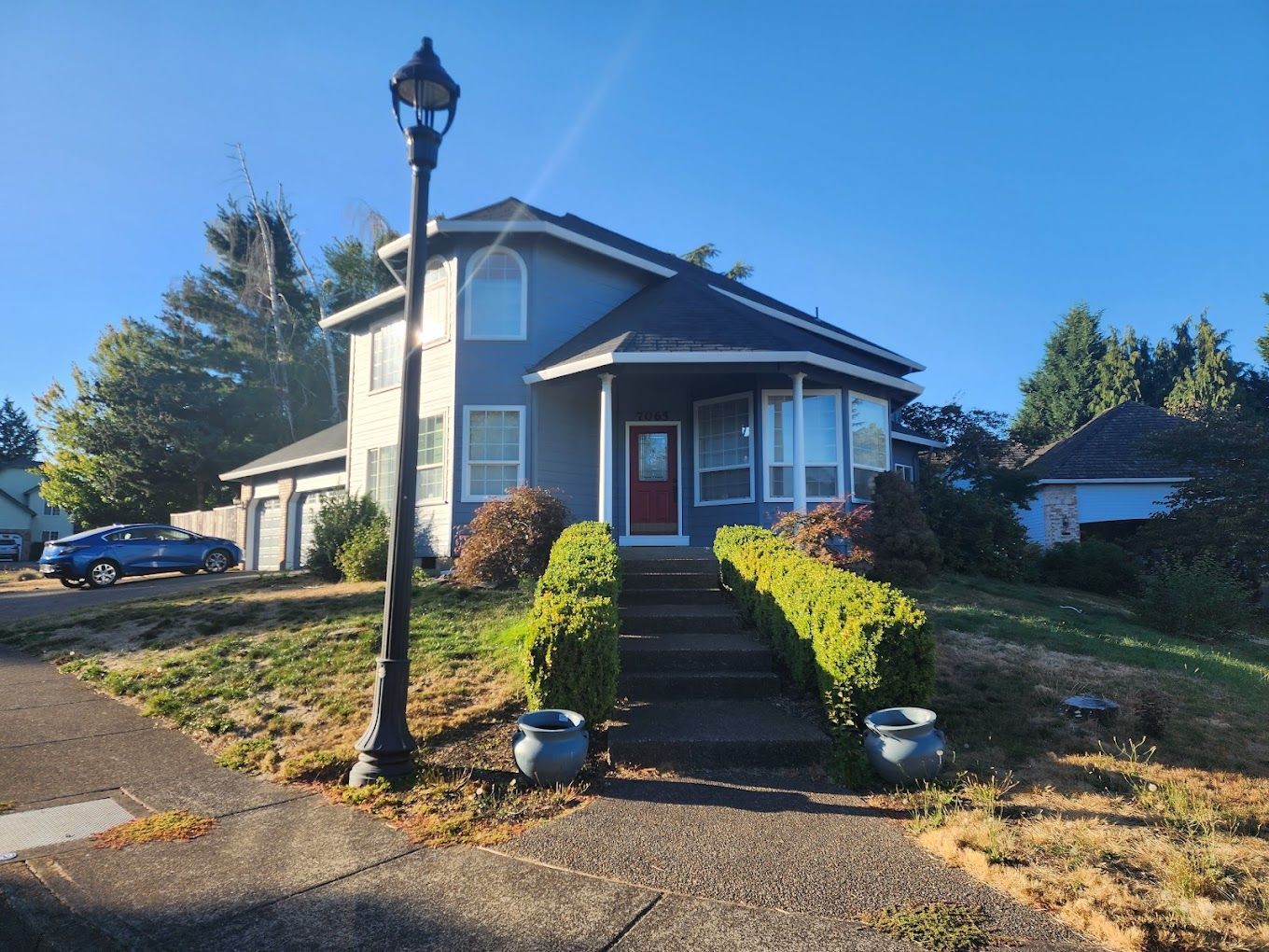A house with a red door and a lamp post in front of it