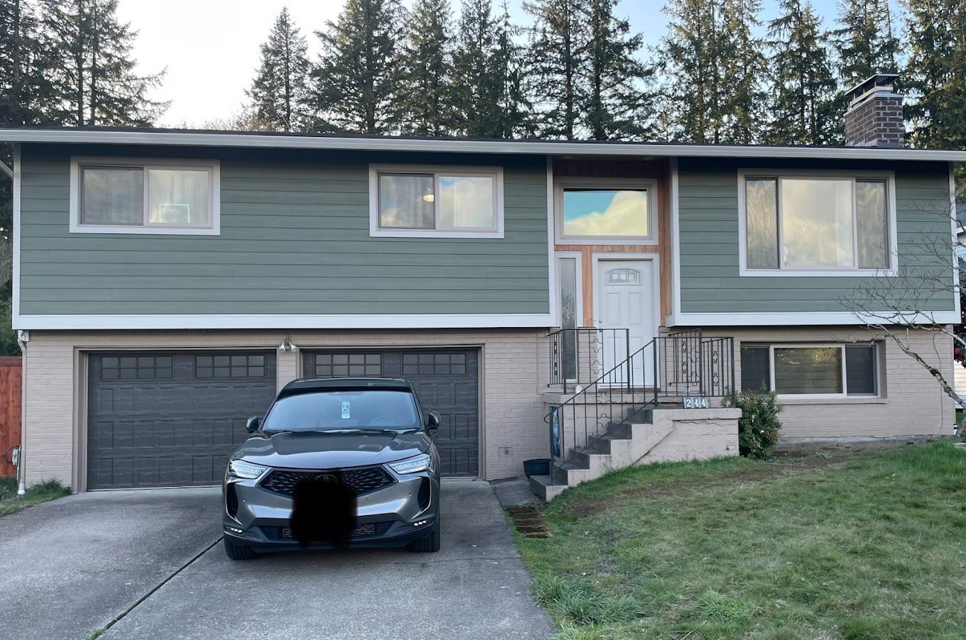 A black car is parked in front of a house.
