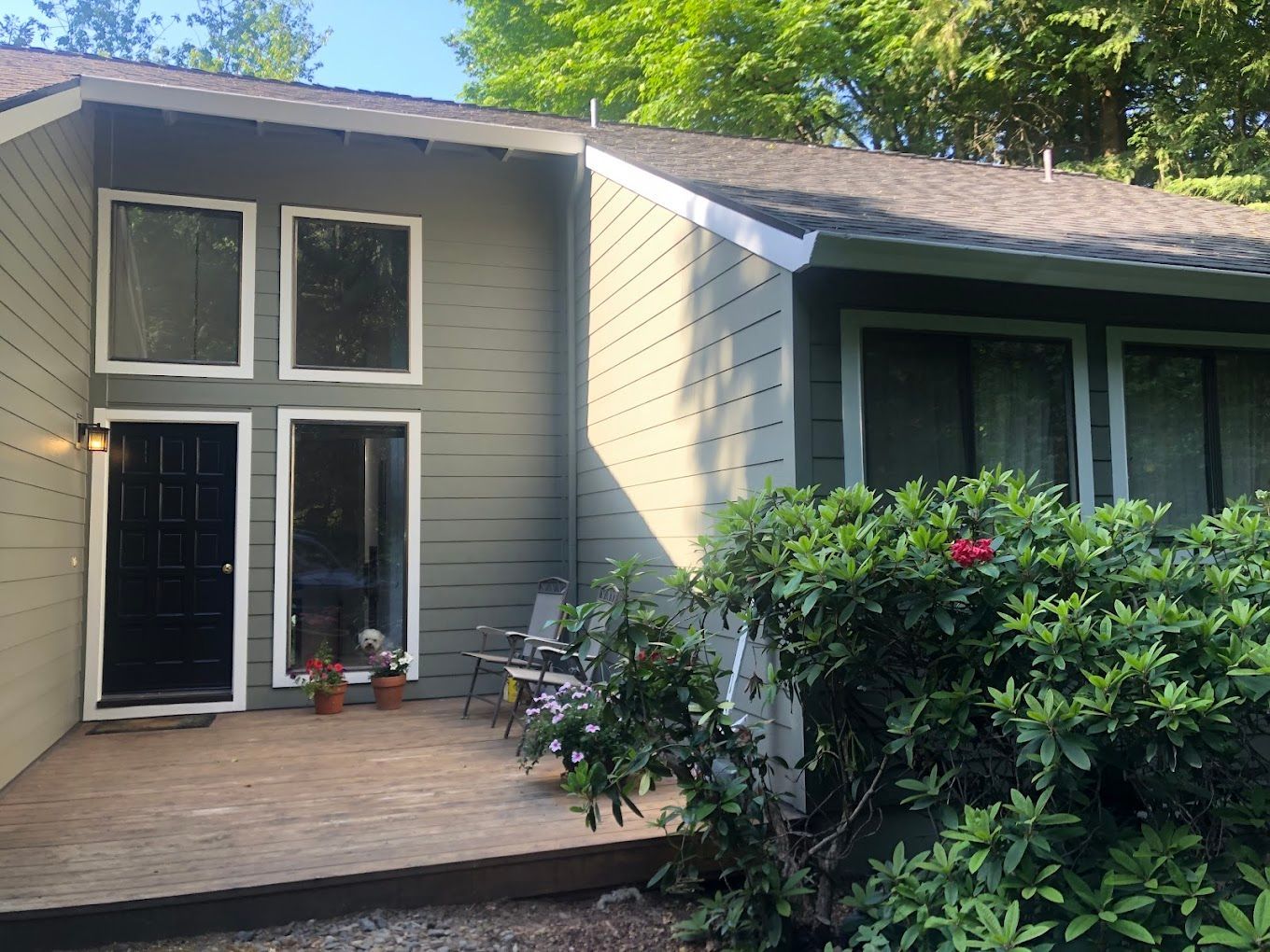 The front of a house with a sliding glass door and a deck.