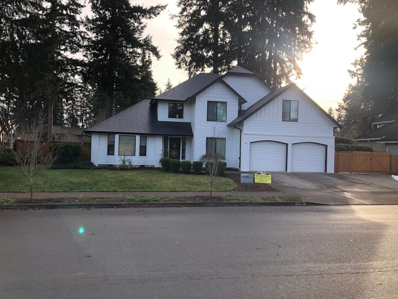 A large white house with a yellow sign in front of it.