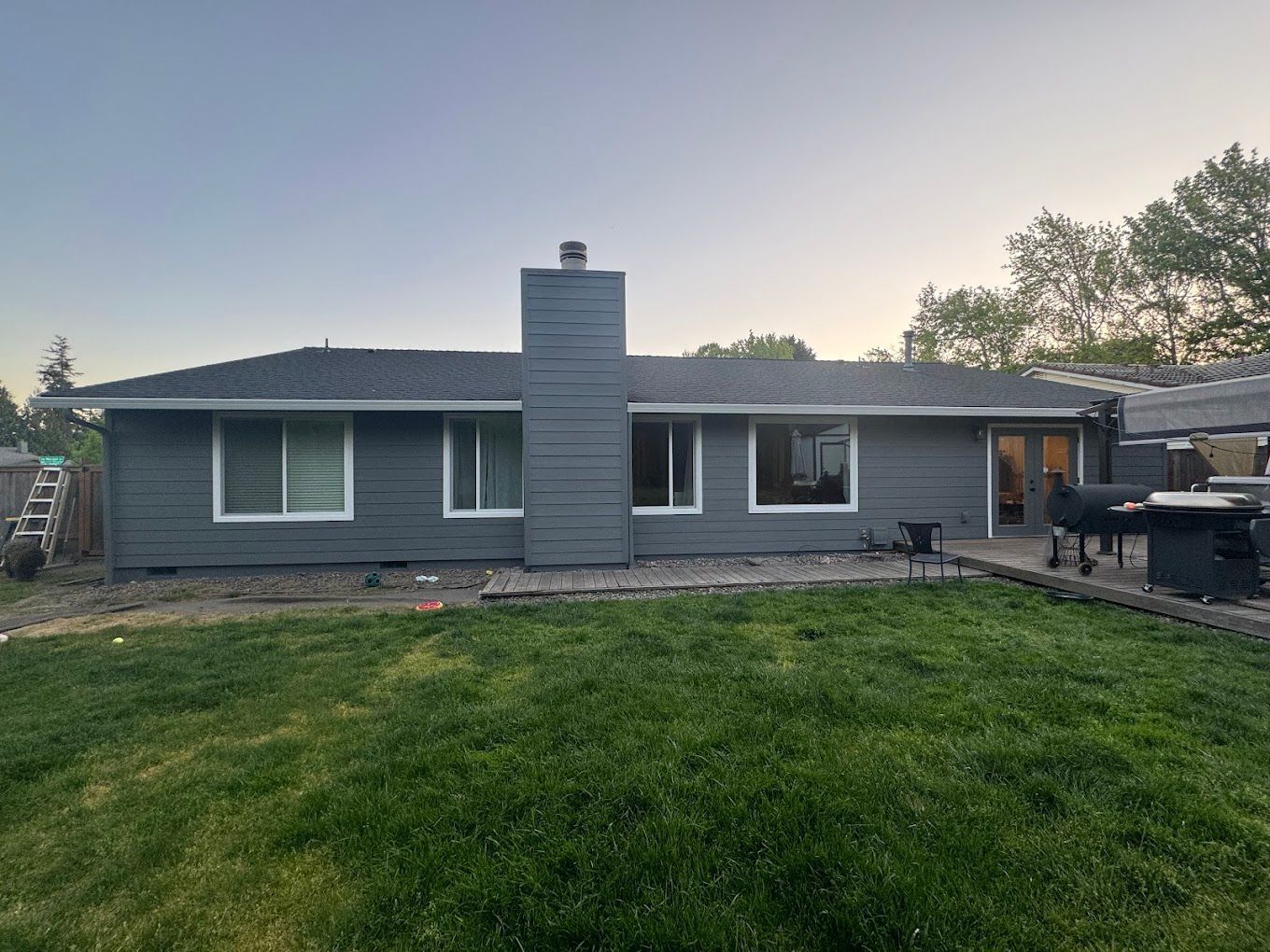 The back of a house with a large lawn in front of it.