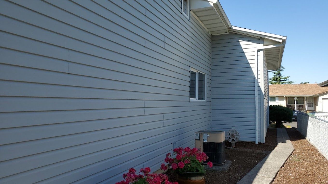The side of a house with flowers in front of it