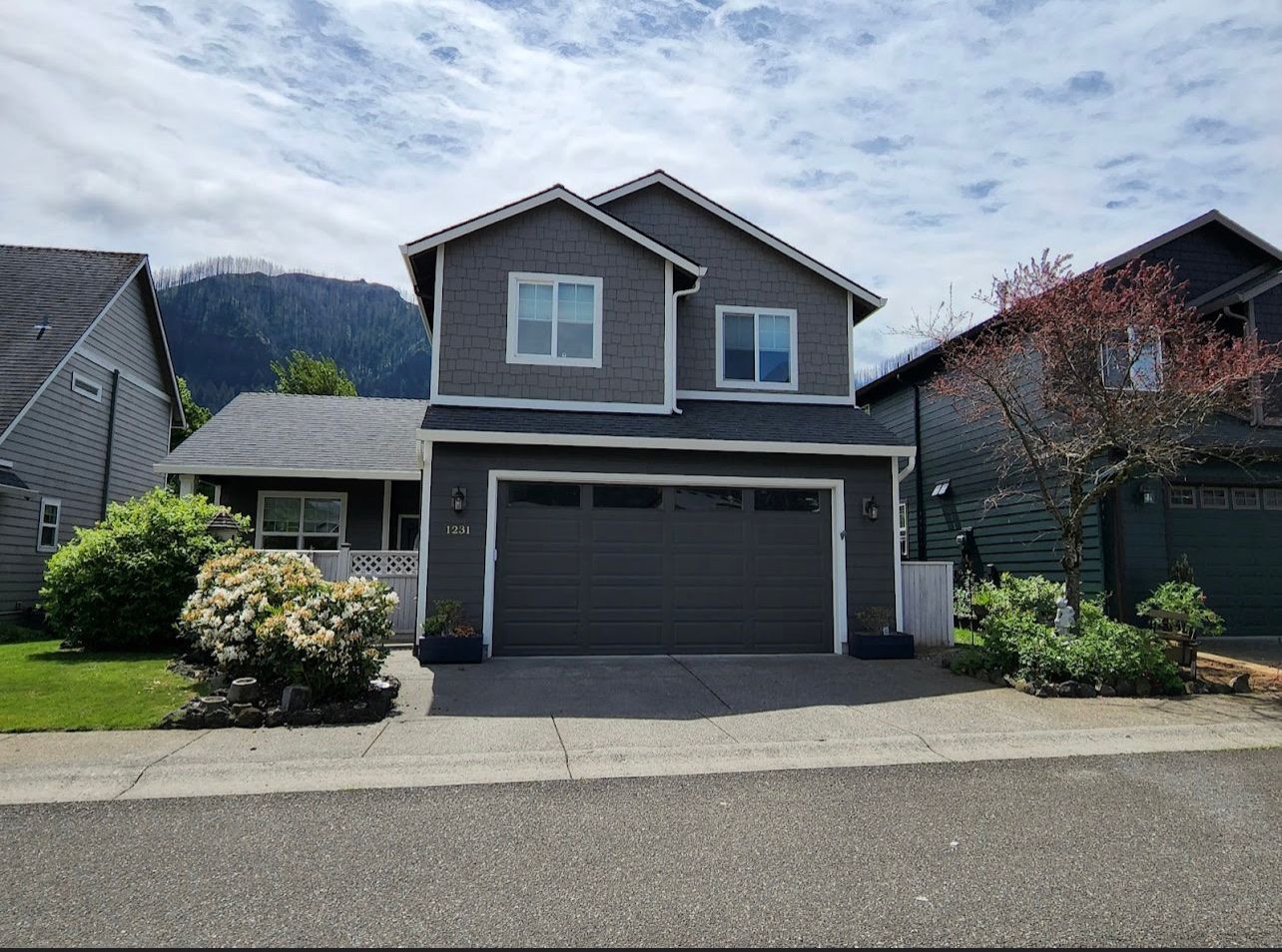 A white house with a for sale sign in front of it.