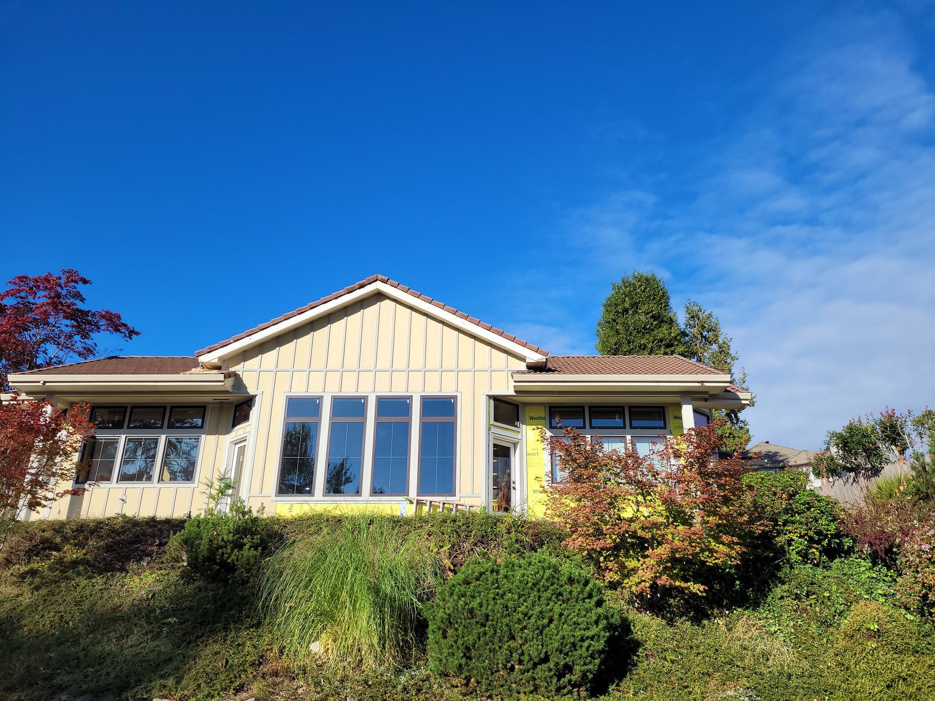 A house with a lot of windows is sitting on top of a hill.