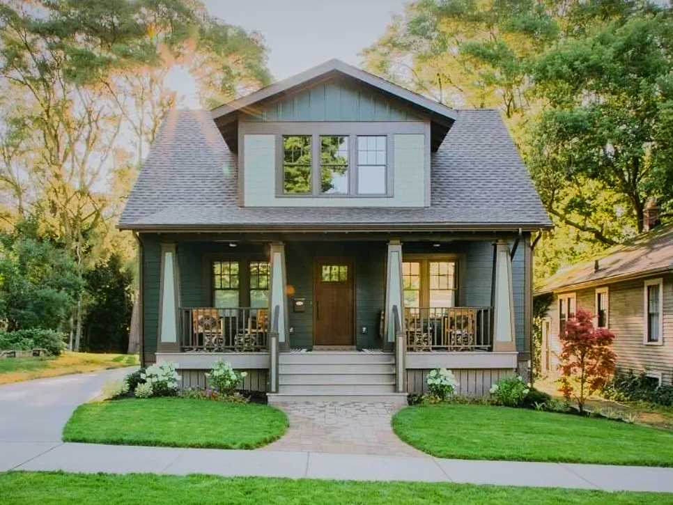 A small house with a porch and stairs in front of it