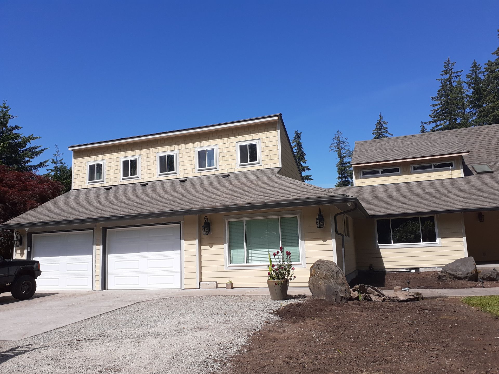 A house with two garage doors and a truck parked in front of it