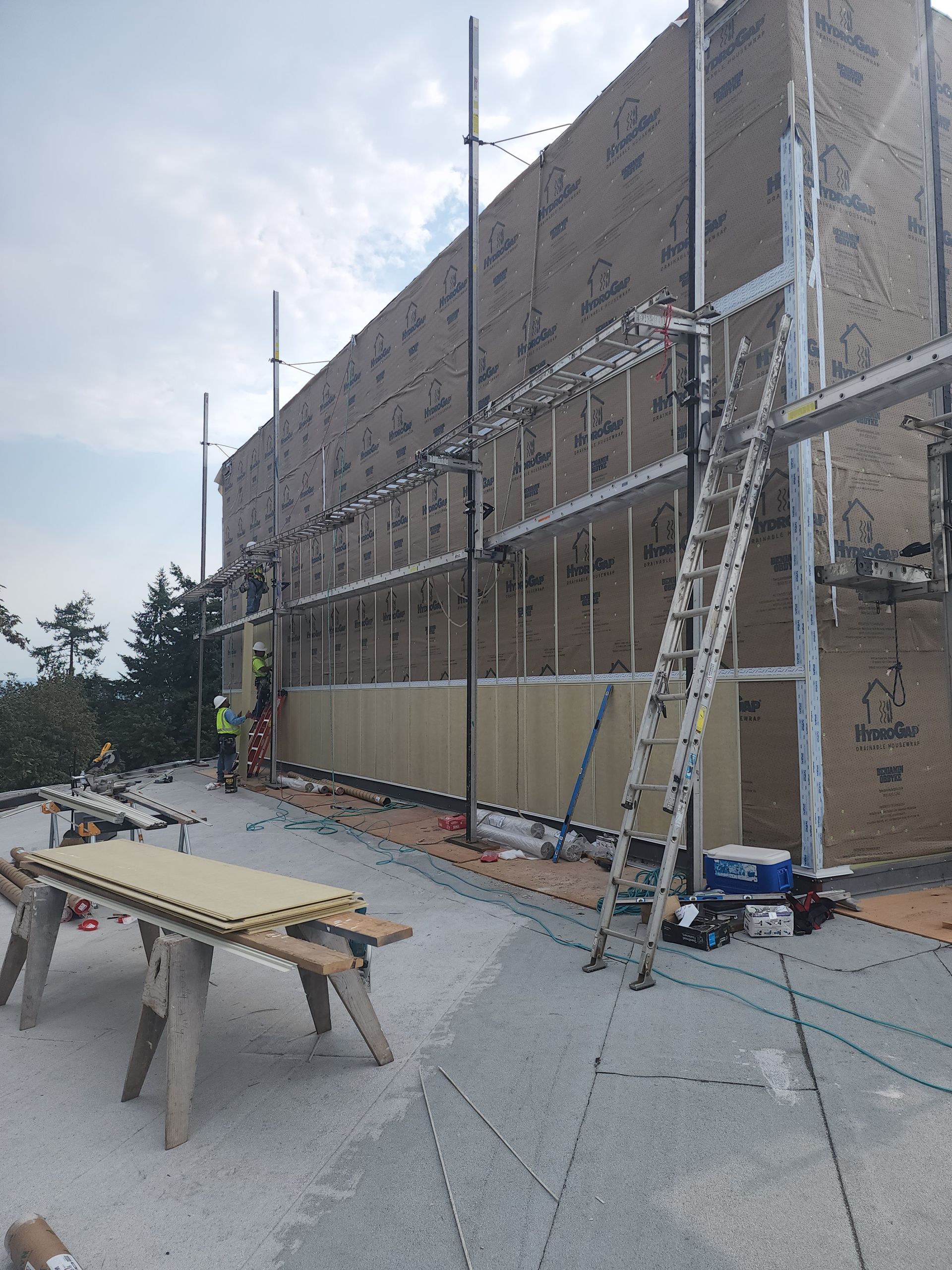 A large building is being built with a ladder on the side of it