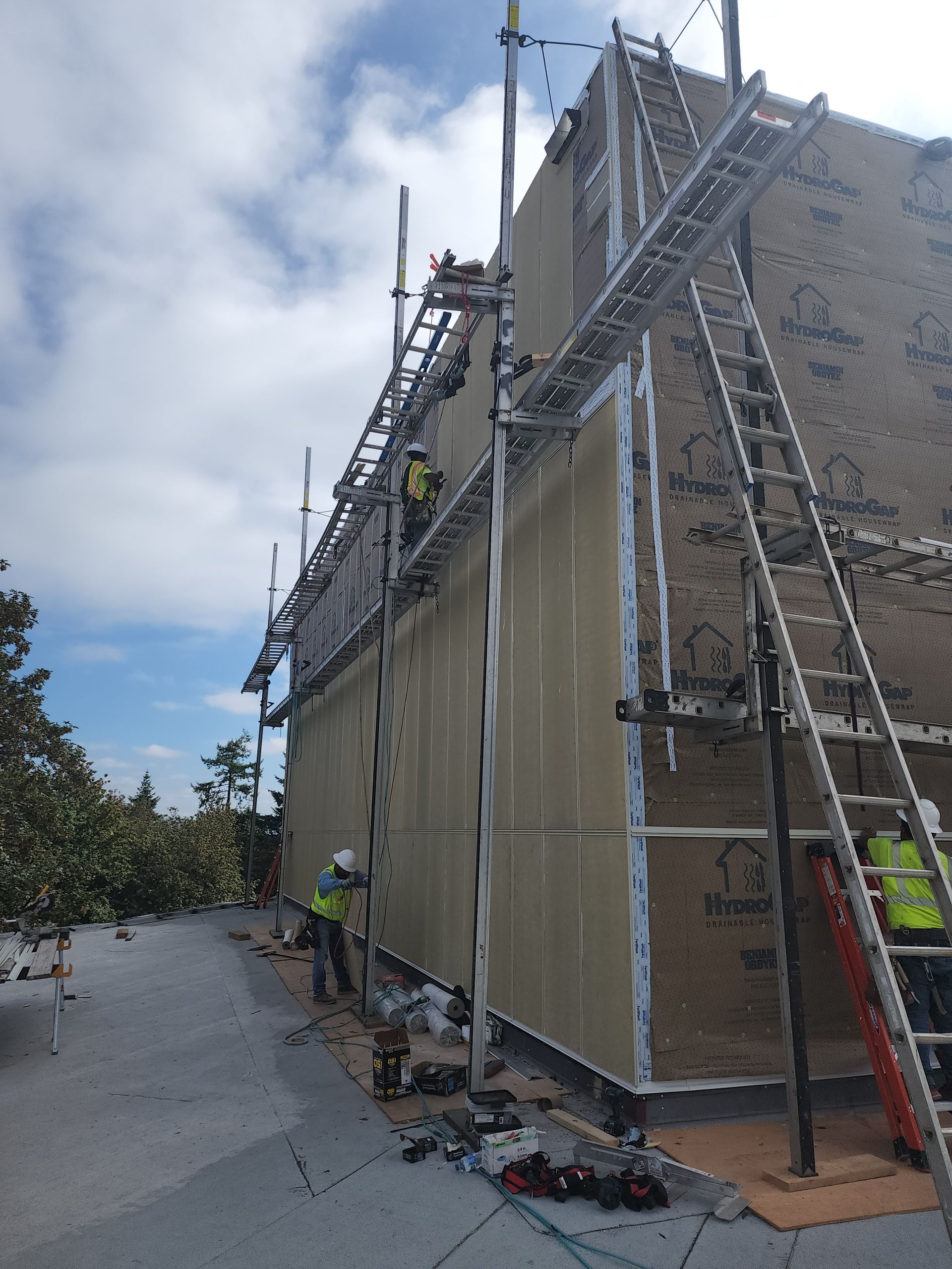 A building is being built with scaffolding and a ladder.
